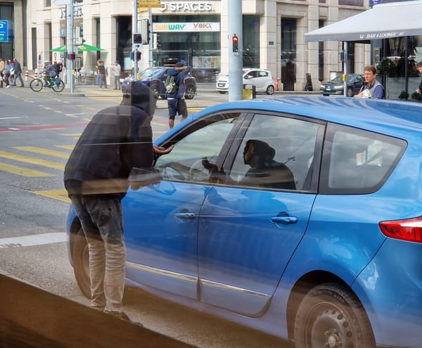 A person begging from a car driver in Switzerland