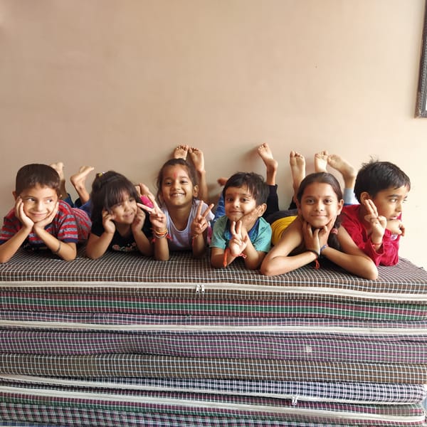 children playing on a pile of mattresses